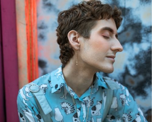 A photo showing the profile of a person with their eyes closed, shown from their shoulders up.